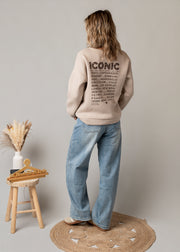 Jean coupe ballon délavé porté par une femme, vue de dos, pull beige, jean ballon