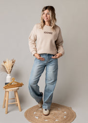 Sweat molletonné imprimé au dos porté par une femme, silhouette entière, jean large, de face