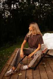 T-shirt large col rond chocolat porté par une femme, assise, fauteuil, plaid