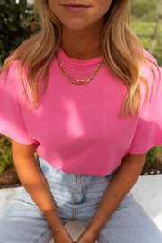 T-shirt ample manches courtes rose porté par une femme, vue rapprochée, collier, t-shirt rose