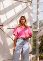T-shirt ample manches courtes rose porté par une femme, silhouette entière, serre, jean