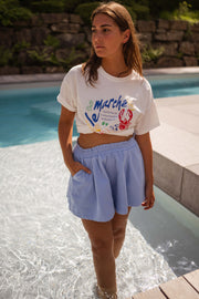T-shirt imprimé col rond porté par une femme, silhouette entière, piscine, short bleu