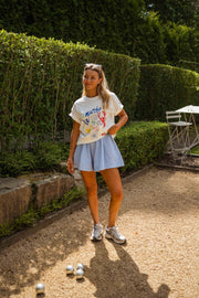 T-shirt imprimé col rond porté par une femme, silhouette entière, haie, gravier