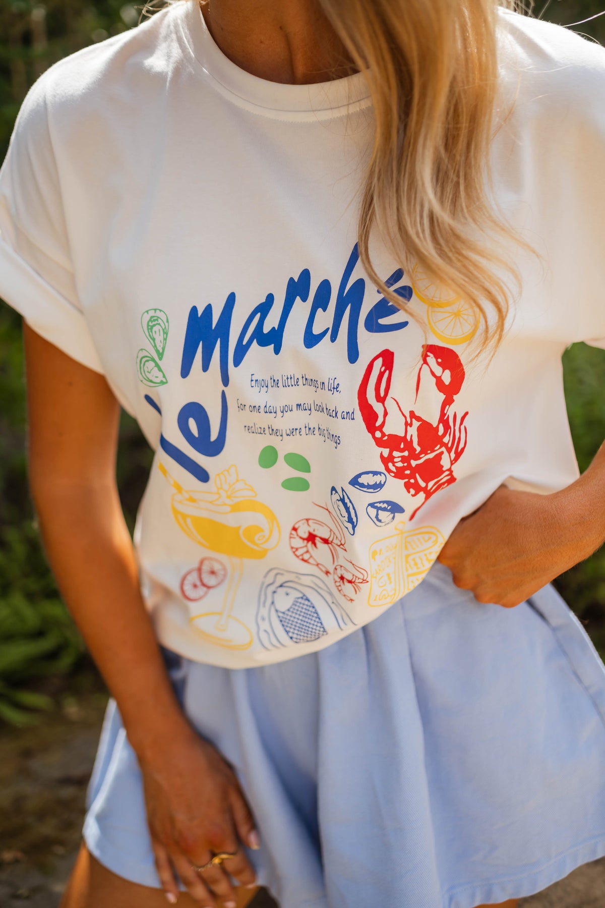 T-shirt imprimé col rond porté par une femme, vue rapprochée, imprimé coloré, short bleu