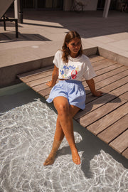 T-shirt imprimé col rond porté par une femme, assise, ponton, pieds dans l'eau