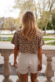 T-shirt léopard col rond porté par une femme, vue de dos, balustrade, cheveux longs
