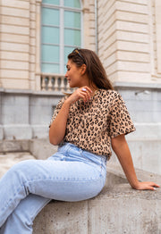 T-shirt léopard col rond porté par une femme, assise, assise, jean clair