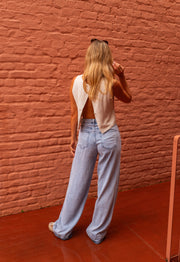 Top fluide effet lin beige porté par une femme, vue de dos ouvert, jean clair