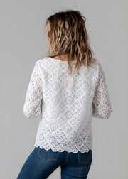 Top dentelle géométrique doublé porté par une femme, vue de dos, dentelle blanche, jean