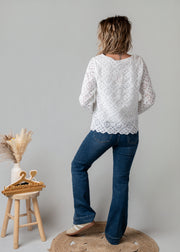 Top dentelle géométrique doublé porté par une femme, vue de dos, jean flare, tabouret