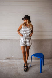 Top éponge rayé col rond porté par une femme, silhouette entière, casquette noire, short rayé, tabouret bleu