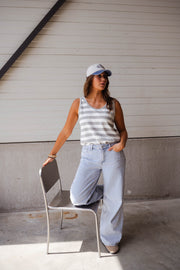 Top éponge rayé col rond porté par une femme, vue de trois-quarts, casquette, chaise, jean clair
