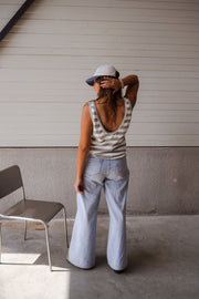 Top éponge rayé col rond porté par une femme, vue de dos, casquette, chaise