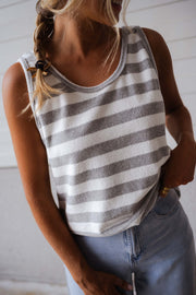 Top éponge rayé col rond porté par une femme, vue rapprochée, rayures grises et blanches, tresse