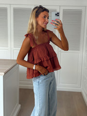 Top à volant col droit porté par une femme, vue de trois-quarts, selfie, jean large, de côté