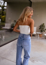 Top bustier à nœud devant porté par une femme, vue de profil, terrasse, jean