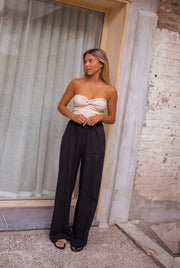 Top bustier à nœud porté par une femme, silhouette entière, porte, rideau gris