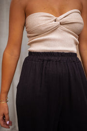 Top bustier à nœud porté par une femme, vue rapprochée, nœud torsadé, pantalon noir