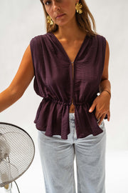 Top fluide dos ouvert porté par une femme, vue rapprochée, taille nouée, jean clair