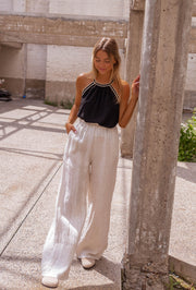 Top fluide à finition crochet porté par une femme, silhouette entière, pilier, plan large