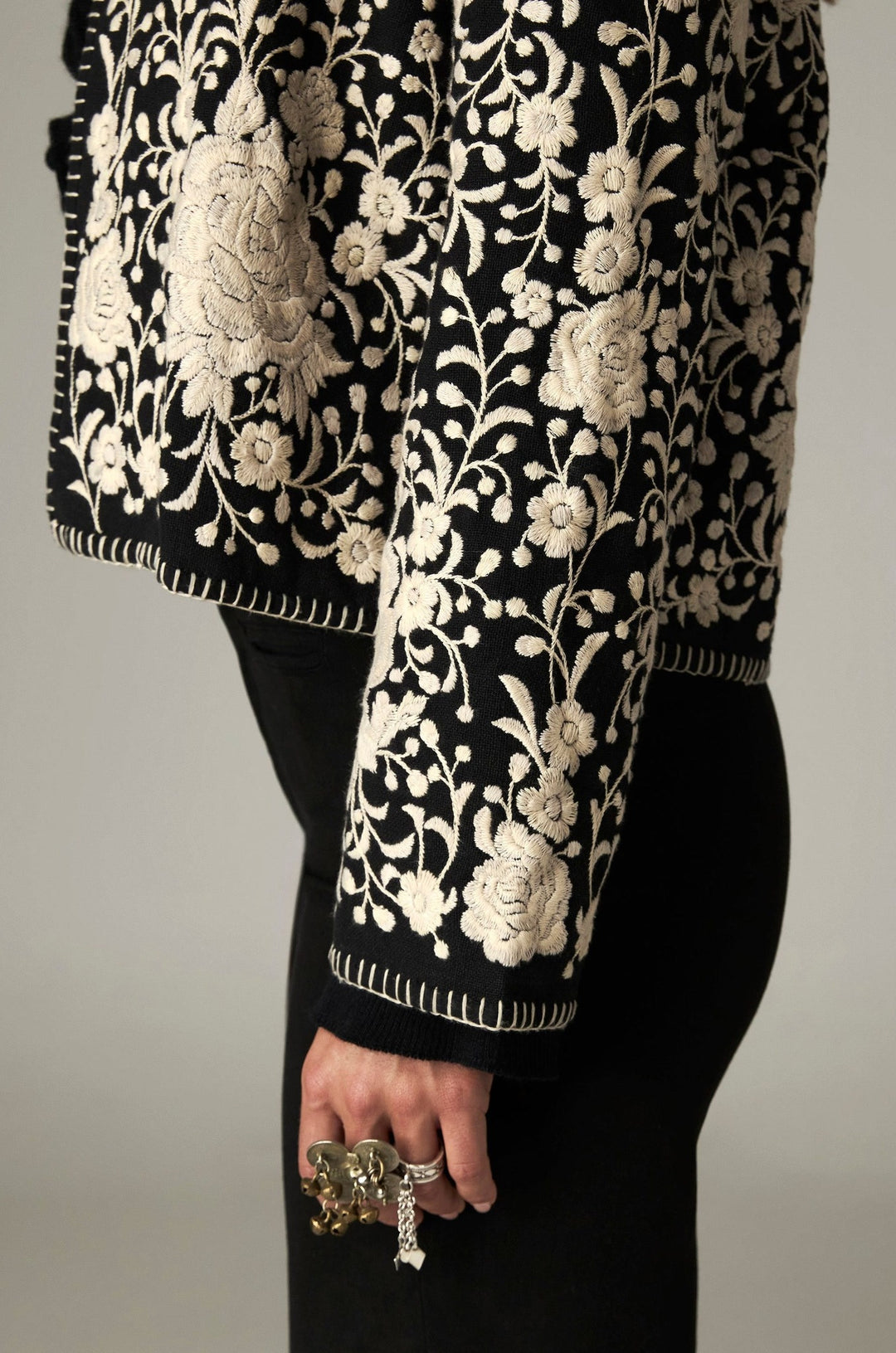Veste ouverte noire à fleurs écrues, détail de la manche