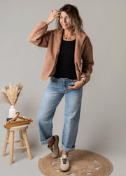 Veste sherpa doublée polaire portée par une femme, vue de trois-quarts, jean large, main sur la veste