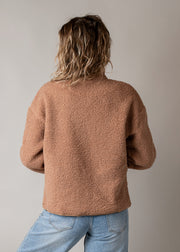 Veste bouclette doublée polaire portée par une femme, vue de dos, jean, fond gris