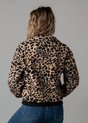 Veste bouclée zippée léopard portée par une femme, vue de dos, imprimé léopard, fond gris