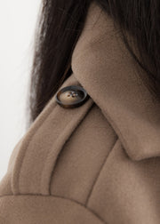 Trench oversize taupe à ceinture — gros plan de l'épaulette boutonnée et de la matière