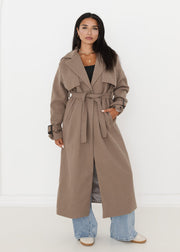 Trench oversize taupe à ceinture — vue portée en pied, ceinturé à la taille