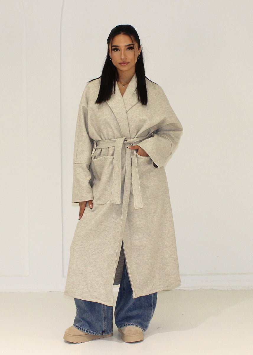 Manteau long beige à poches plaquées — vue portée de face.