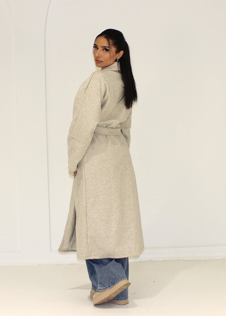 Manteau long beige à poches plaquées — vue de dos.