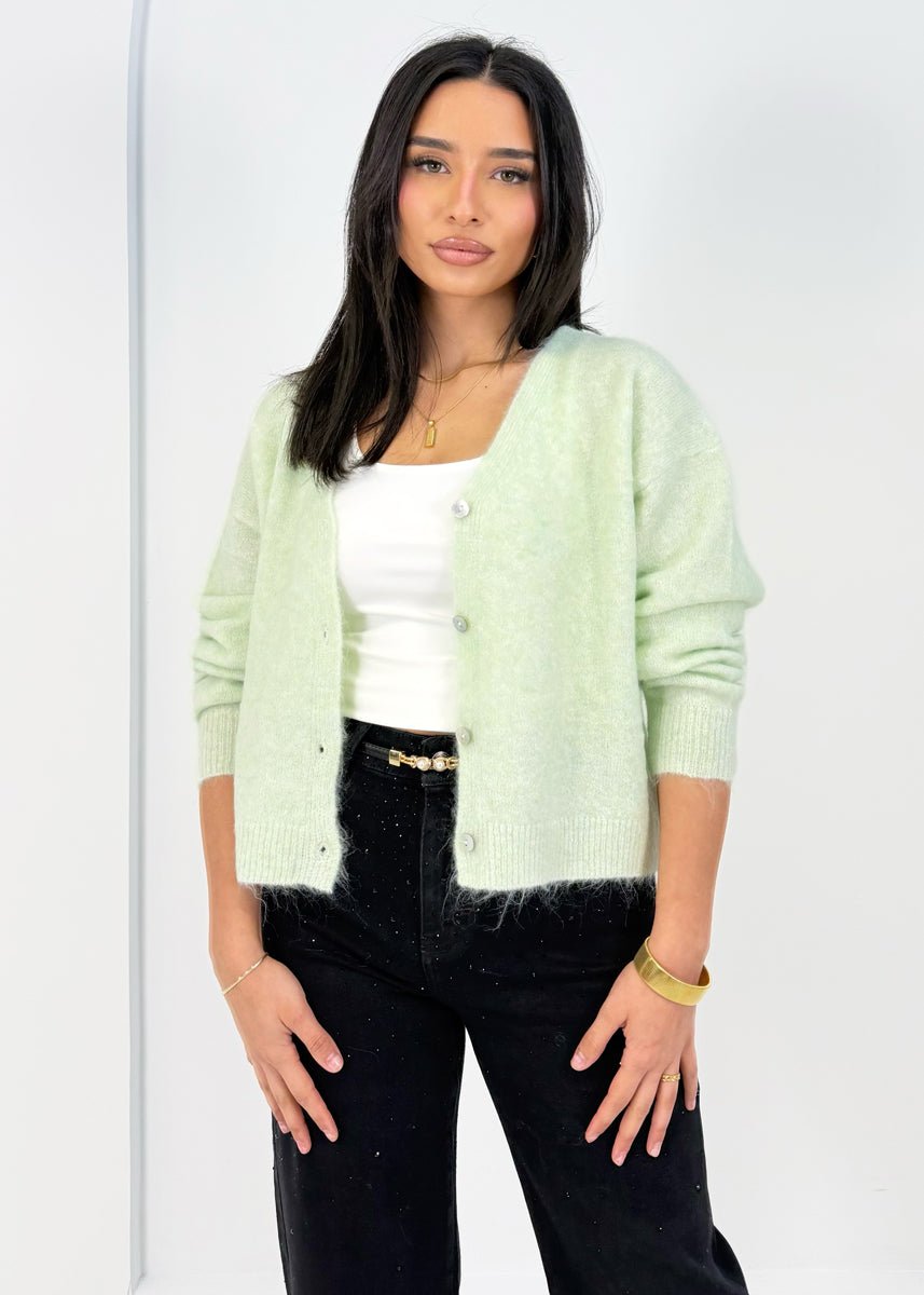 Cardigan doux menthe — vue portée de trois-quarts, cadrée à la taille, sur un débardeur blanc