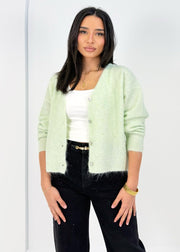Cardigan doux menthe — vue portée de trois-quarts, cadrée à la taille, sur un débardeur blanc