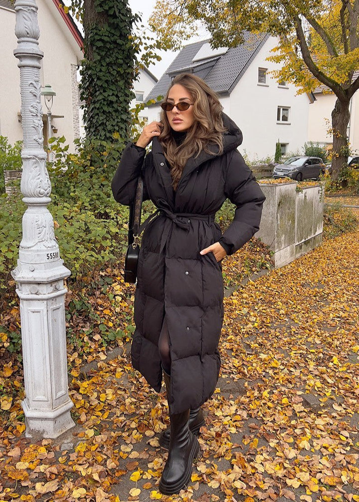 Manteau matelassé noir à capuche — vue portée en extérieur.