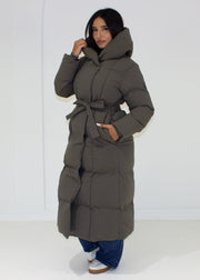 Veste d’hiver grise à capuche — vue portée de trois-quarts, capuche relevée, jean large
