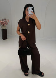 Ensemble brun à boutons dorés, vue de trois quarts avec sac noir