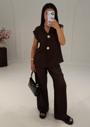 Ensemble brun à boutons dorés, vue de face avec sac noir